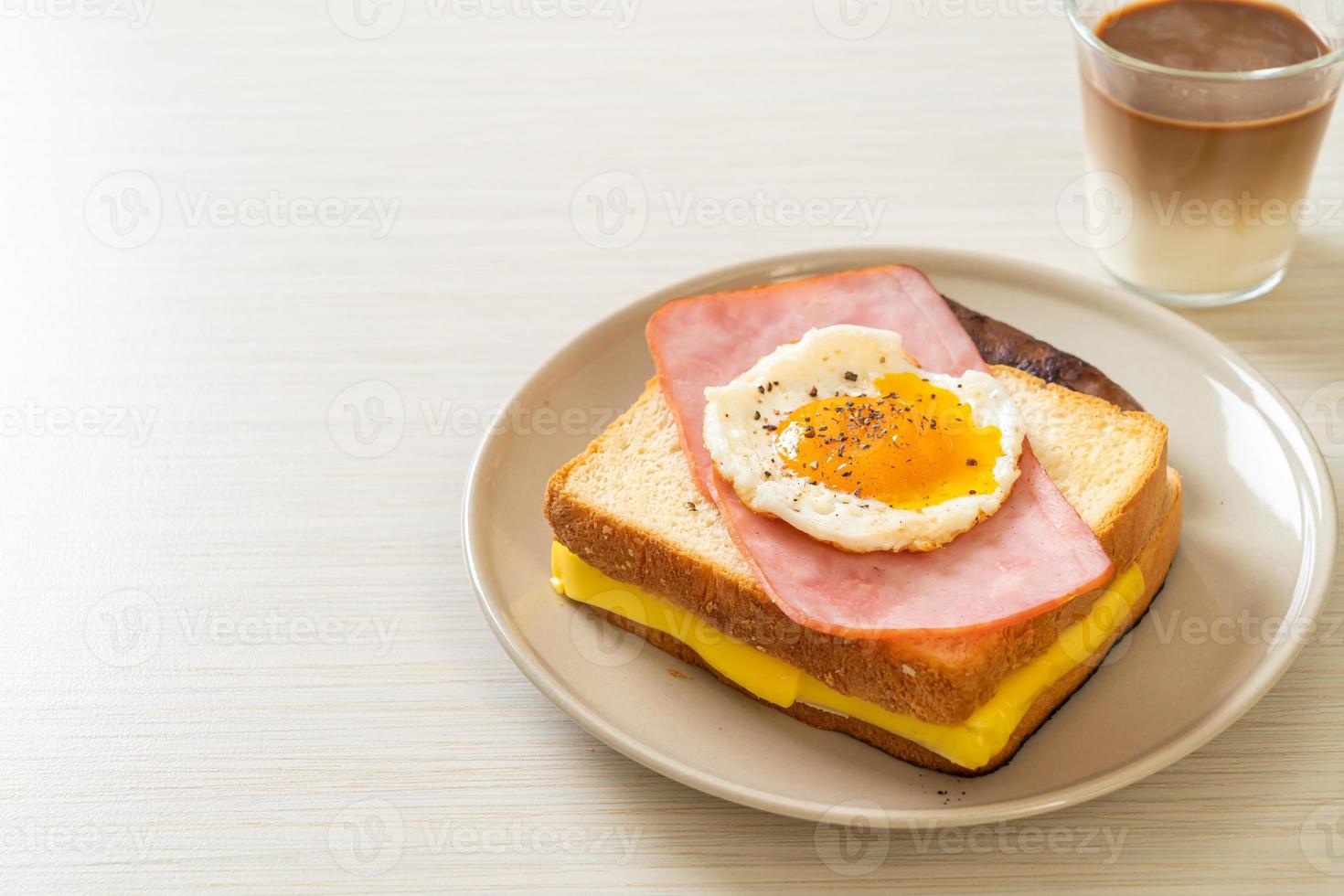 Bread toasted cheese topped ham and fried egg with pork sausage photo