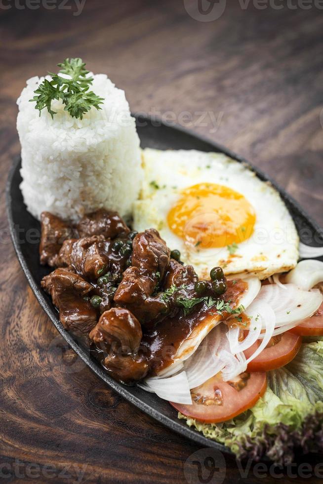 Cambodian traditional Khmer beef Lok Lak meal on wooden table photo