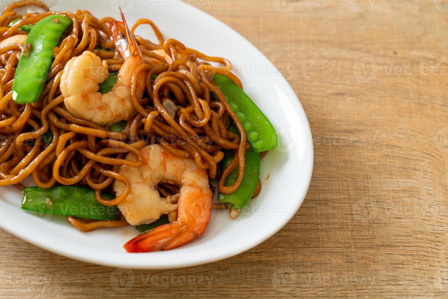 Stir-fried yakisoba noodles with green peas and shrimps photo