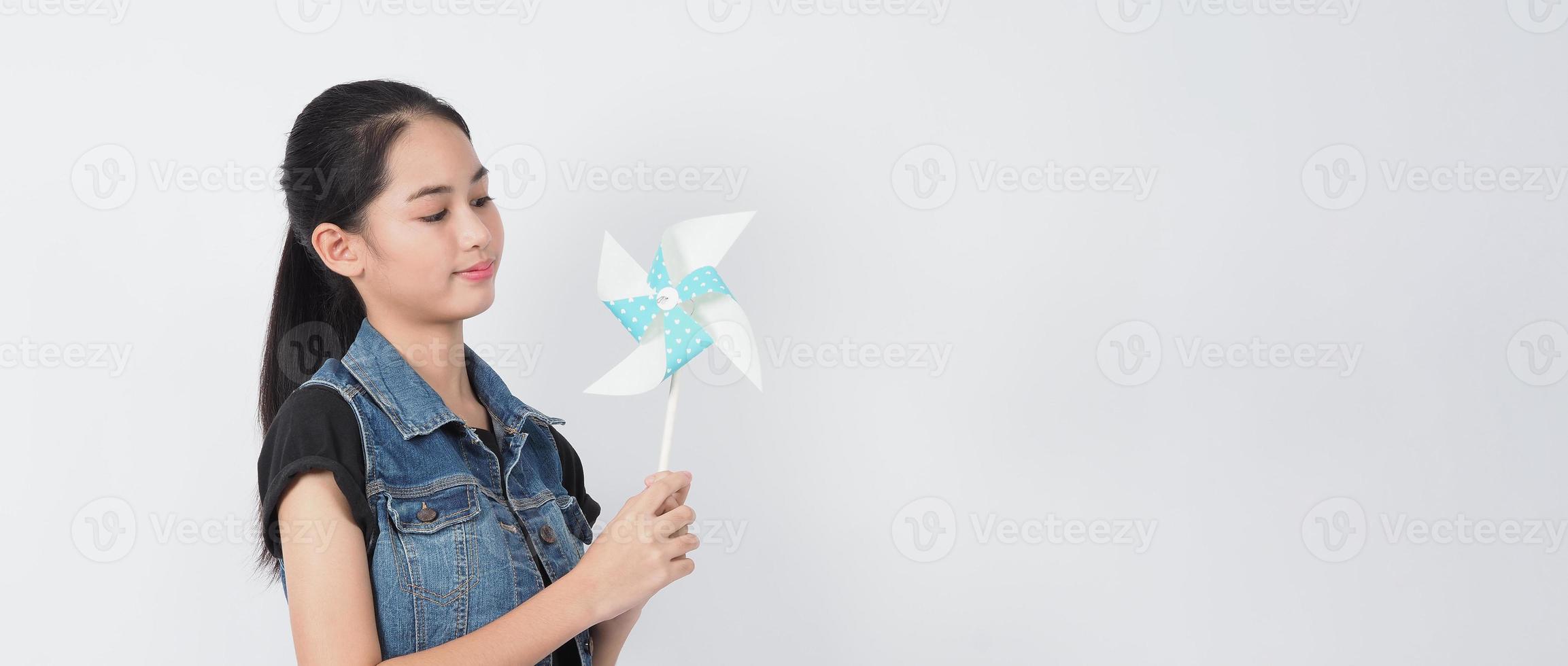 Teenage woman and paper windmill toys. teen with wind wheel stick photo