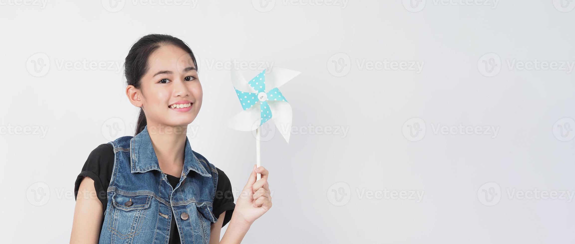 juguetes de molino de viento de papel y mujer adolescente. adolescente con palo de rueda de viento foto