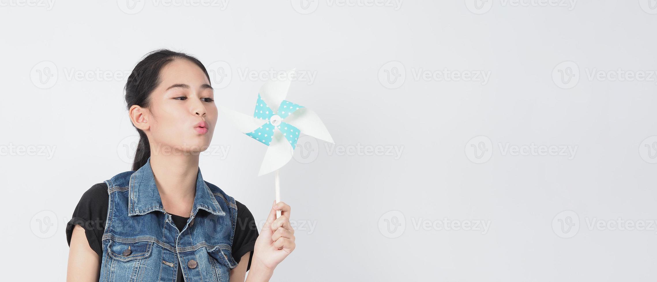 juguetes de molino de viento de papel y mujer adolescente. adolescente con palo de rueda de viento foto