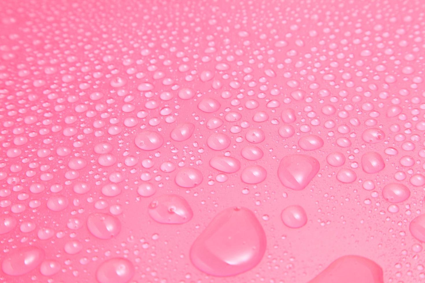 cerrar gotas de agua sobre fondo rosa foto