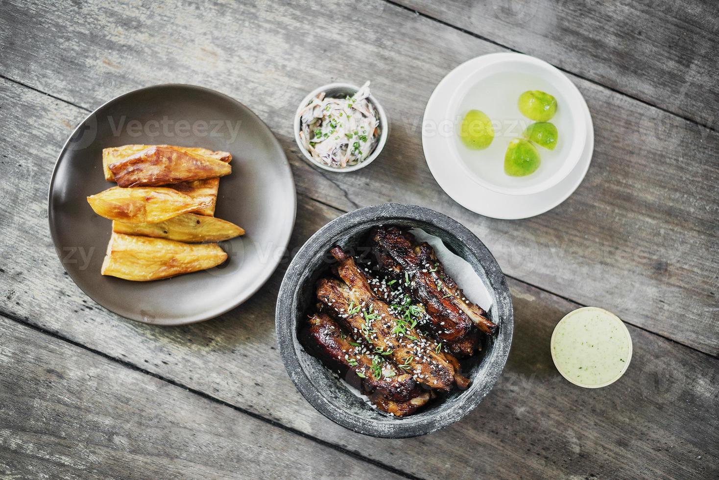 costillas de cerdo con patatas fritas gruesas ensalada de col y mahonesa de ajo foto