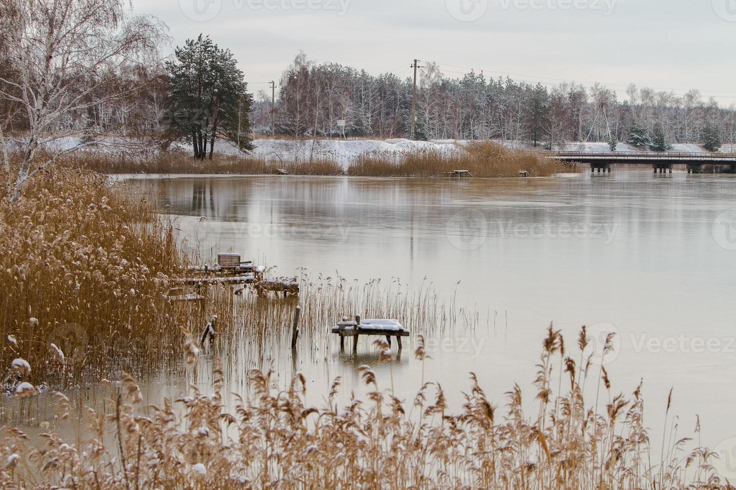 Vista desde la orilla del río cubierto de hielo fino en invierno foto