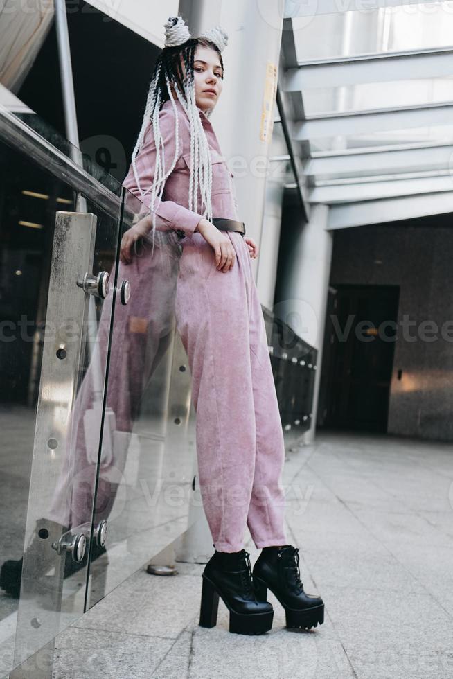 hermosa chica guapa con rastas en toda su longitud. foto en la ciudad