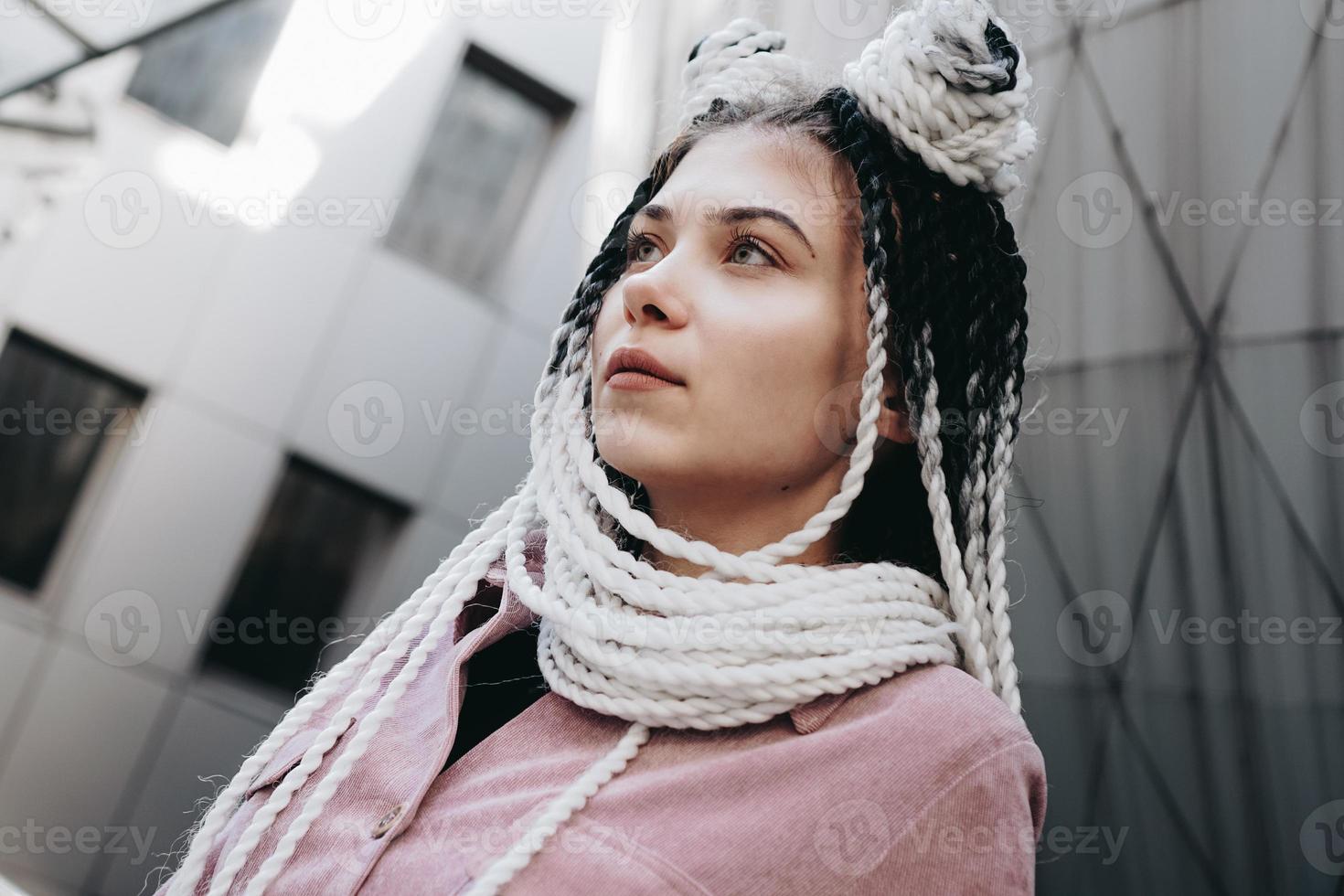 Young woman with futuristic looks. Girl with black and white pigtails photo