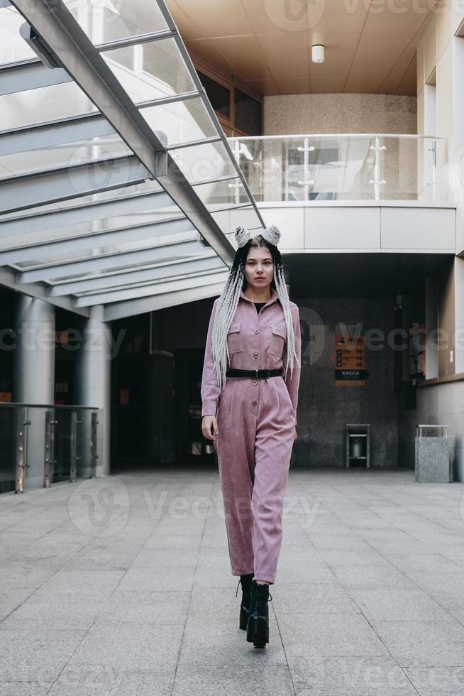 Beautiful cool girl with dreadlocks full length. Photo in the city