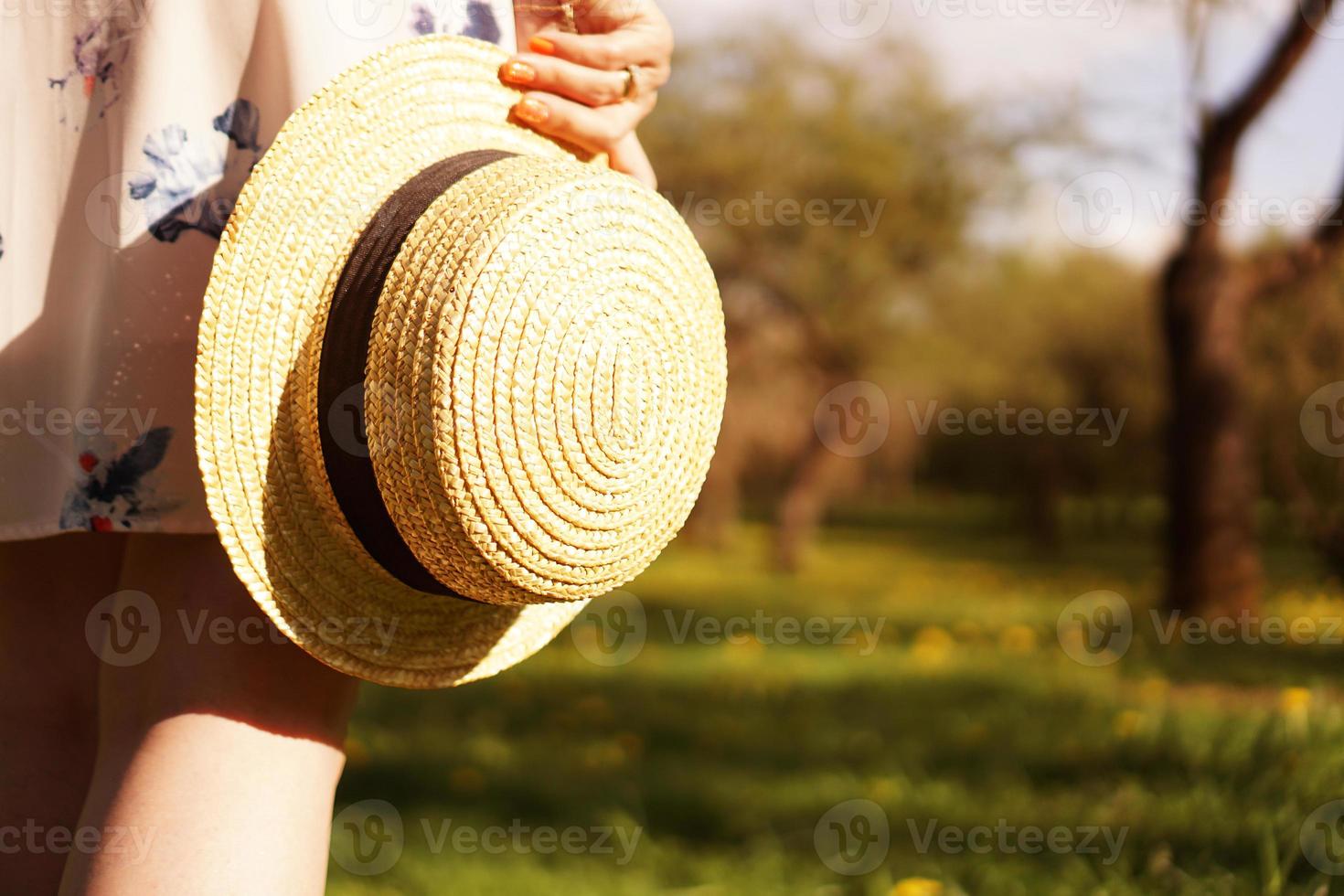 Foto de primer plano - niña con un sombrero de paja con un sombrero en sus manos