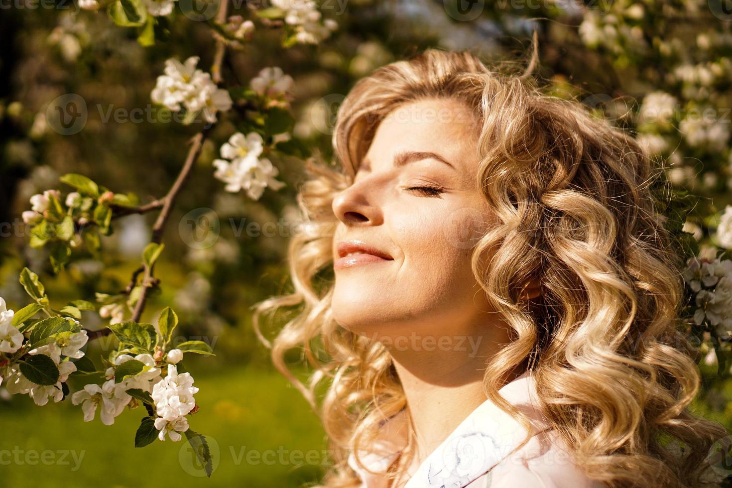 mujer joven romántica en el jardín de primavera entre flor de manzano. foto