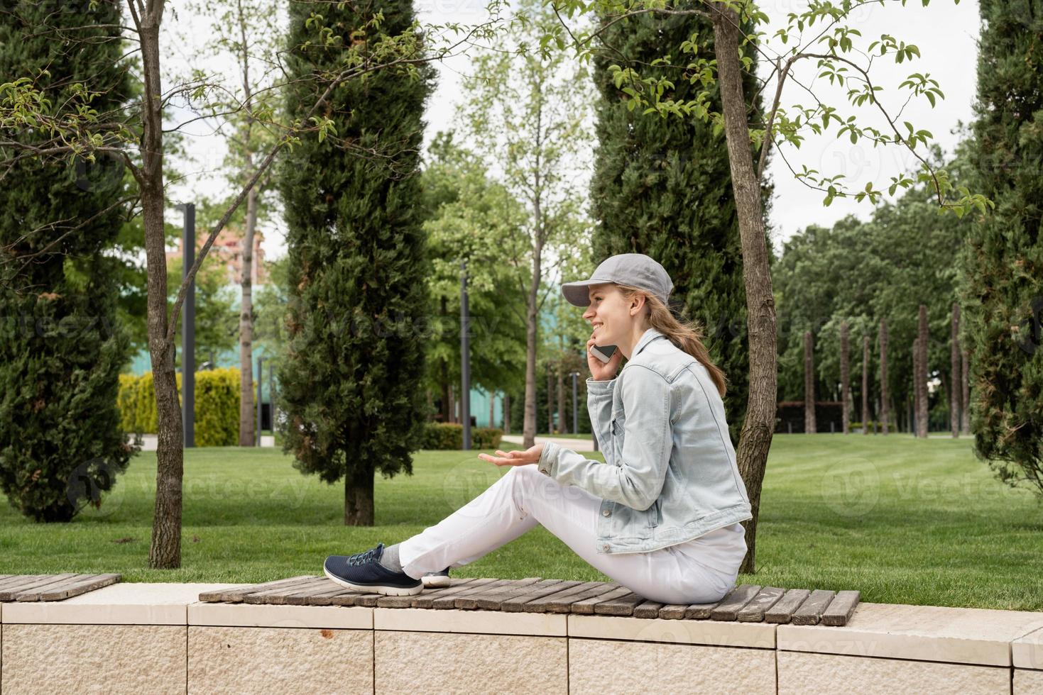 Woman outdoors talking on her mobile phone photo
