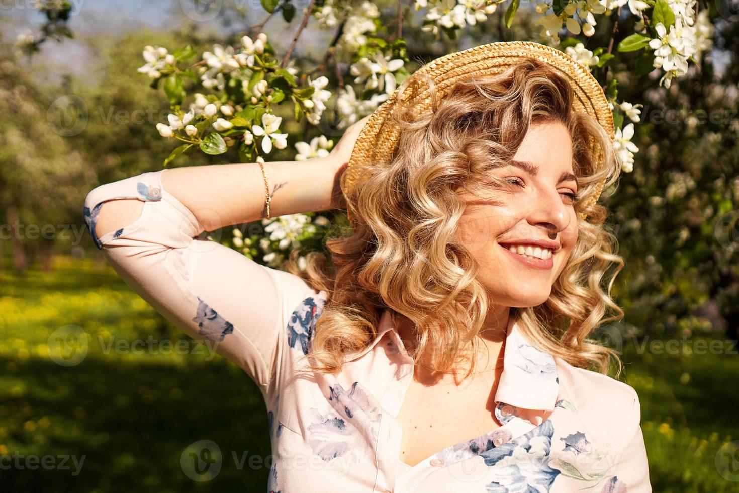 Sonriente mujer de verano con sombrero de paja en el parque foto