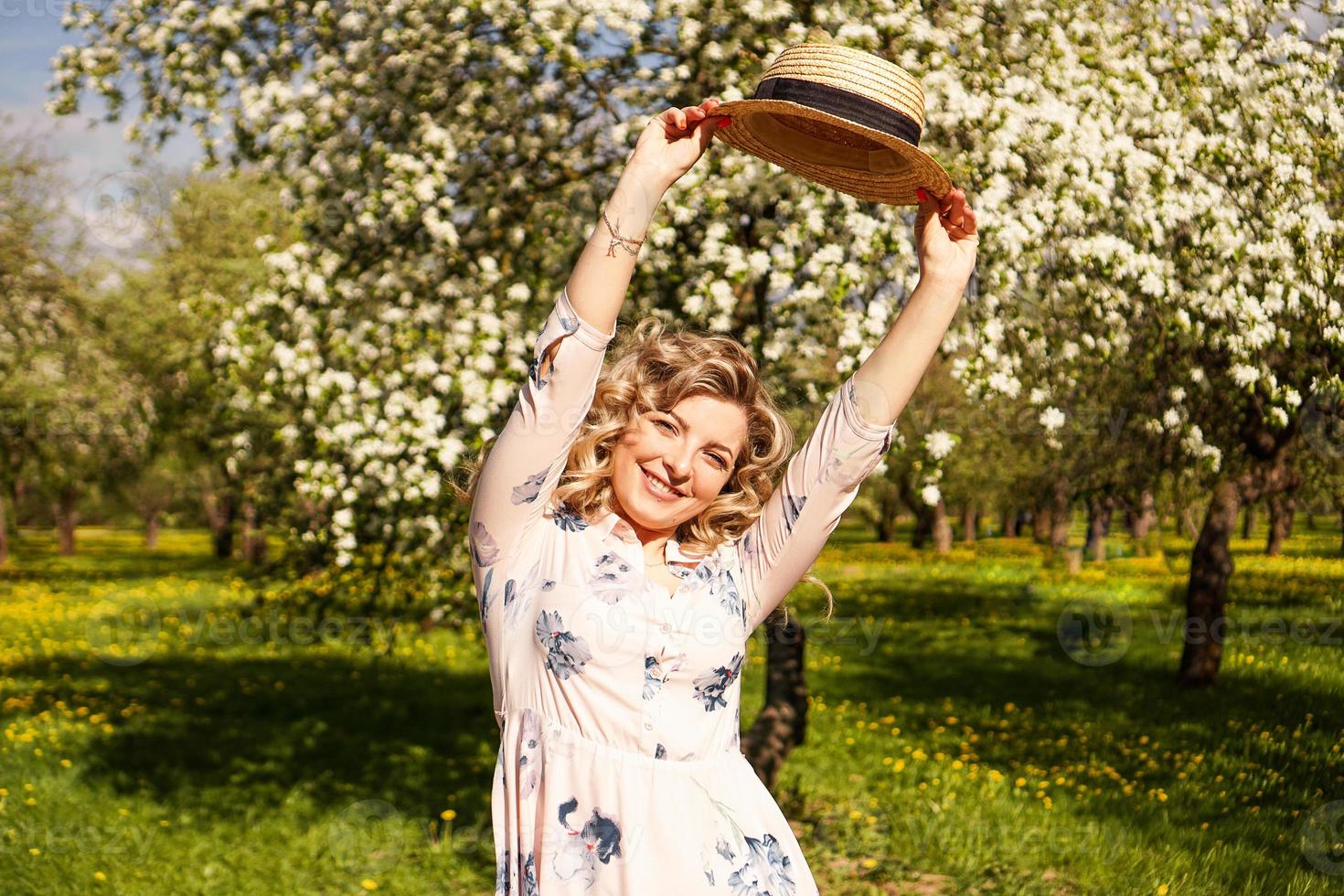 Sonriente mujer de verano con sombrero de paja en el parque foto