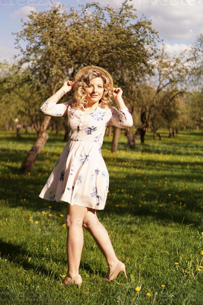 Sonriente mujer de verano con sombrero de paja en el parque foto