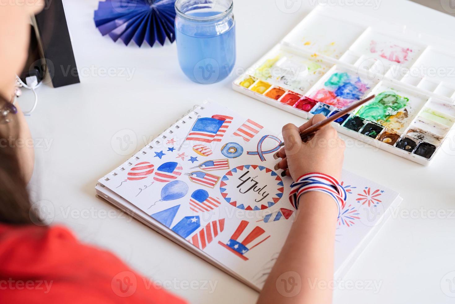 Beautiful woman drawing a watercolor illustration for Independence day photo