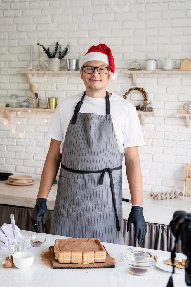 Chef con gorro de Papá Noel cocinando un postre en la cocina foto
