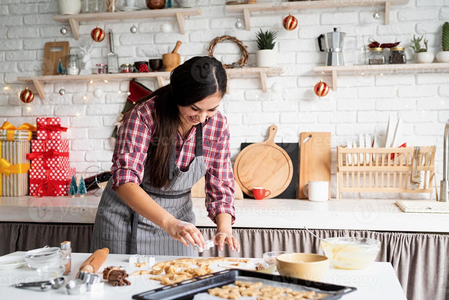 Young brunette woman baking cookies at the kitchen photo