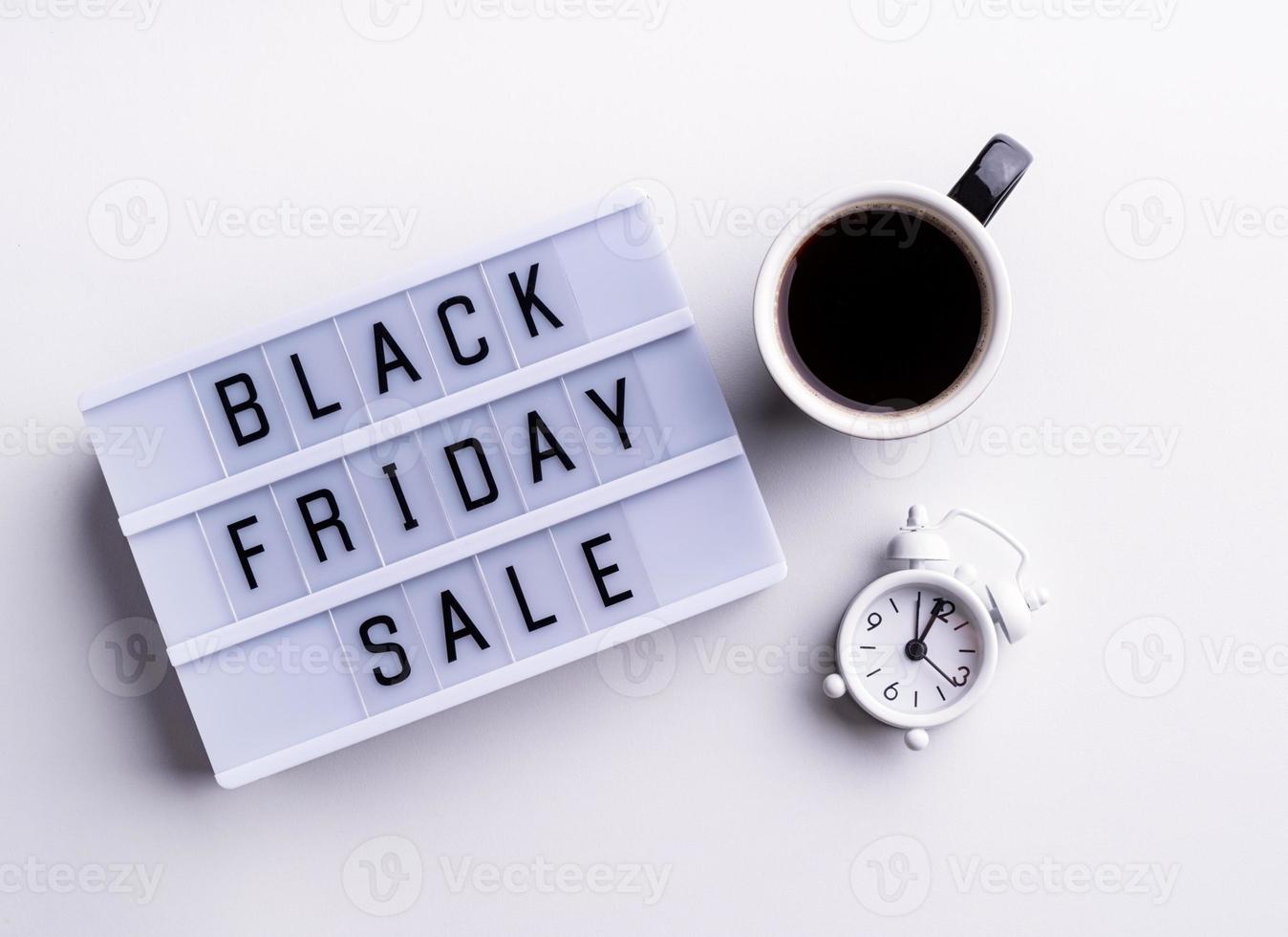 Black Friday Sale words on lightbox with cup of coffee and clock photo