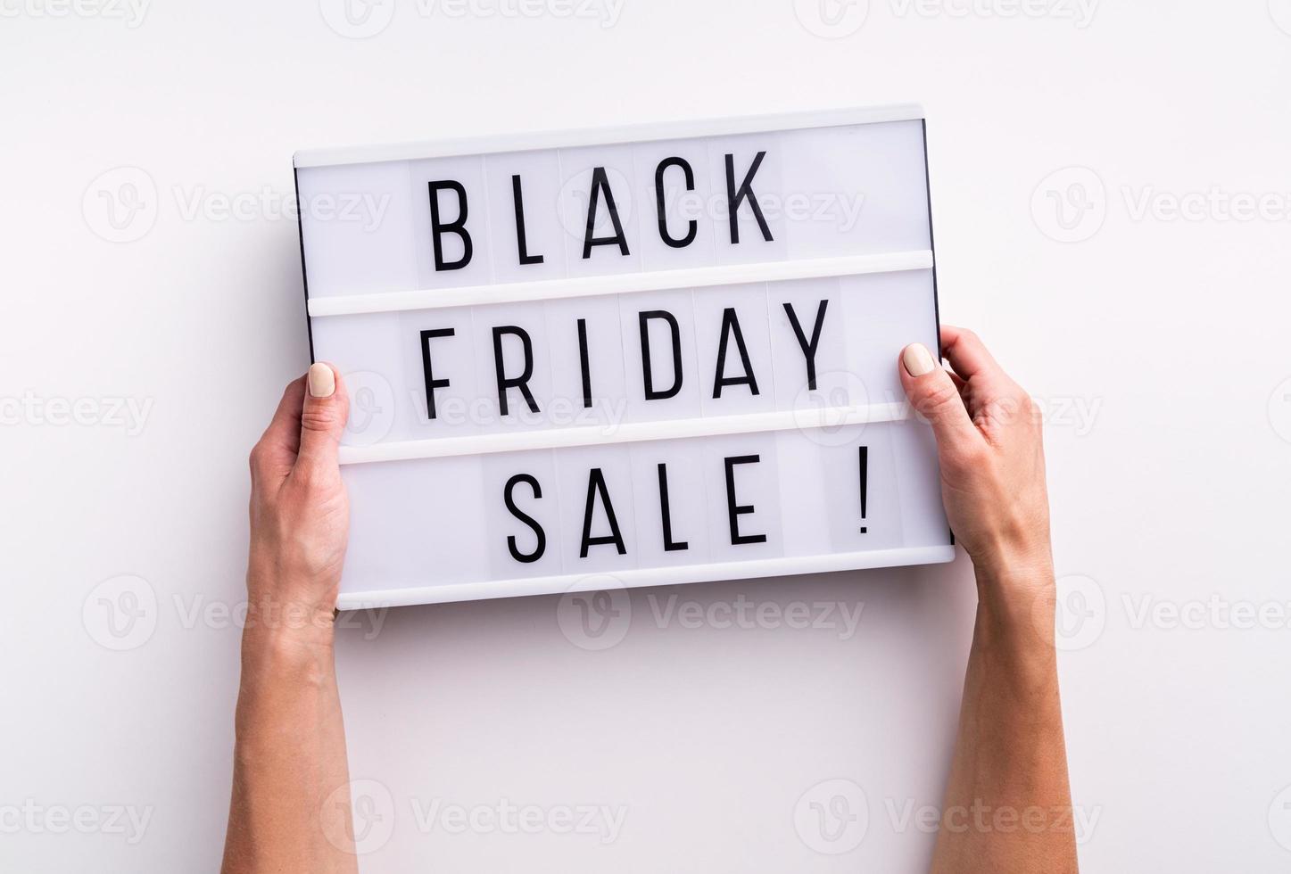 Woman hands holding lightbox with words Black Friday Sale on white photo