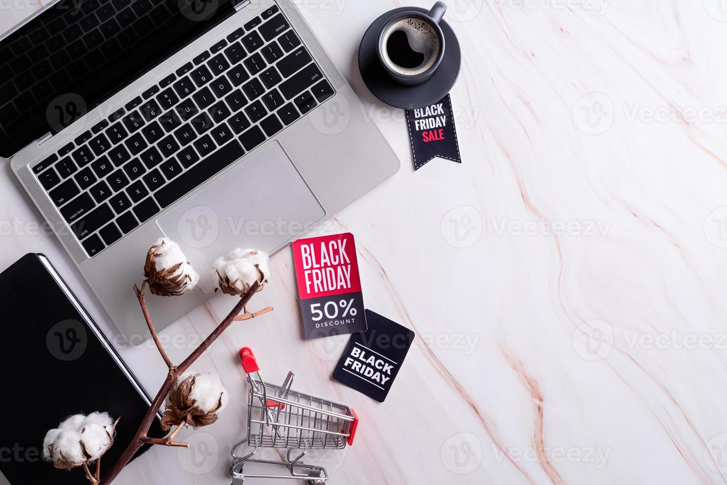 Black Friday Sale words on the tag, workspace with laptop, notebook photo