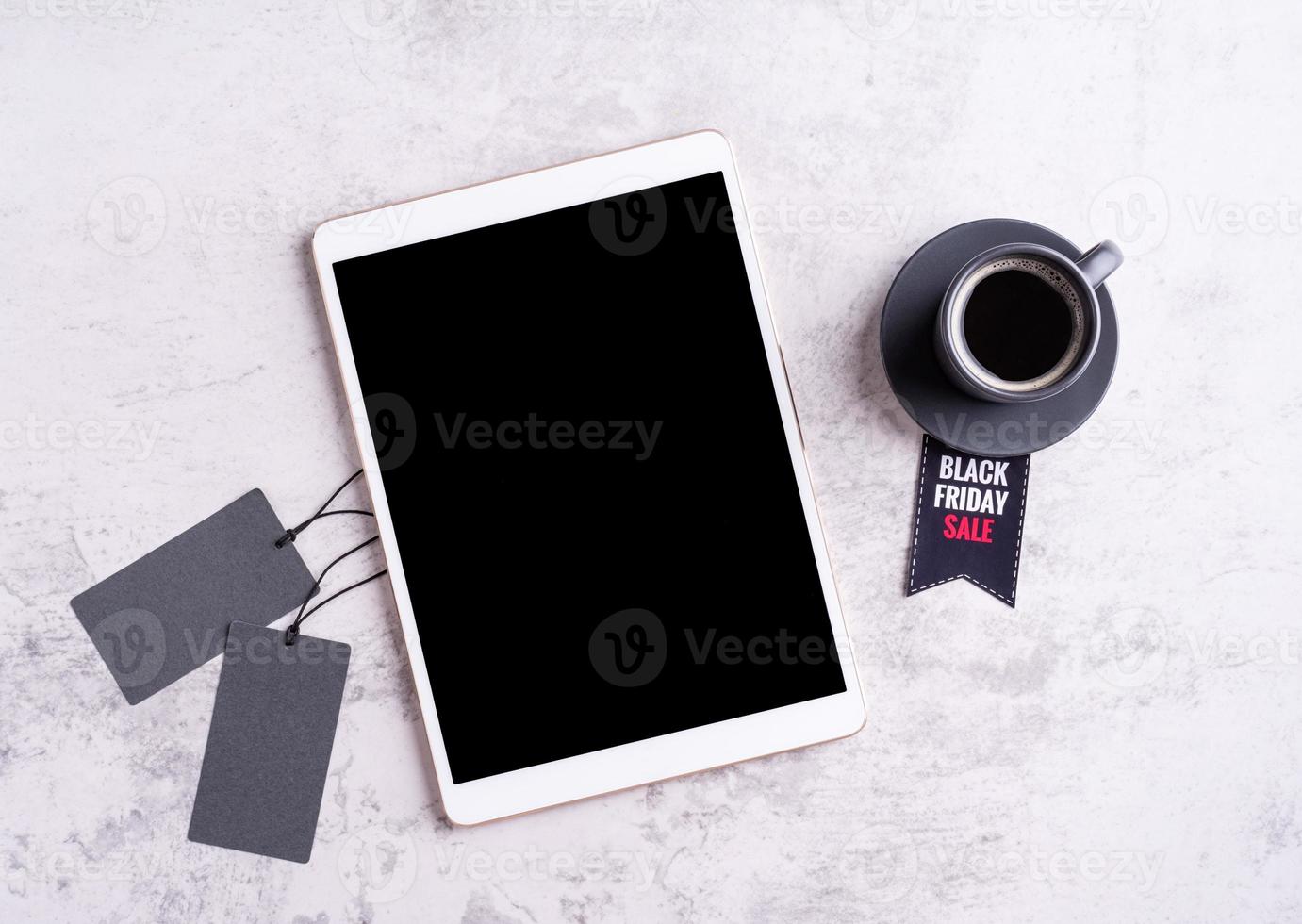 Black Friday Sale words on the tag, tablet and cup of black coffee photo