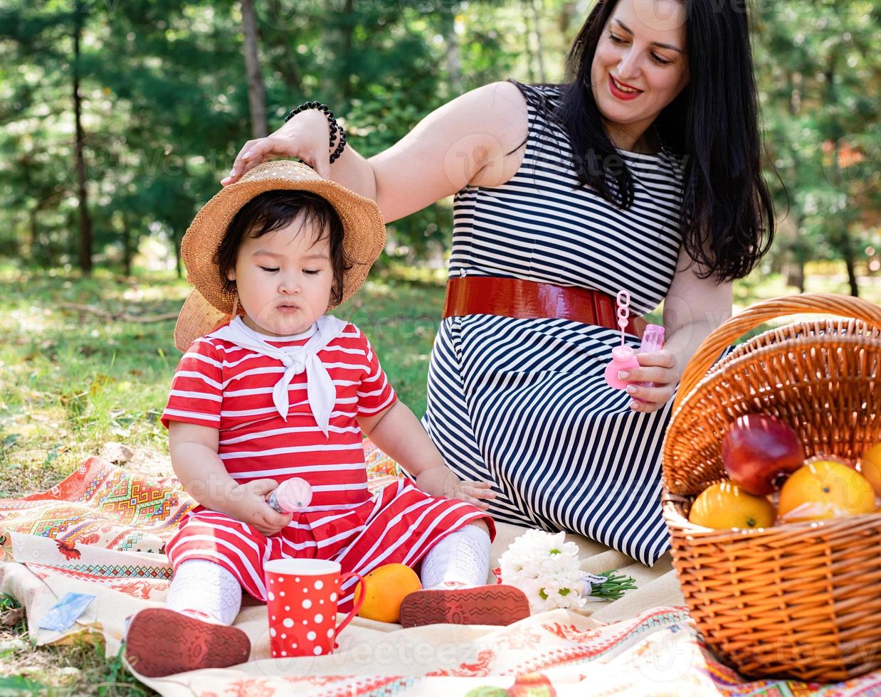 Interracial family of mother and daughter in the park having a picnic photo