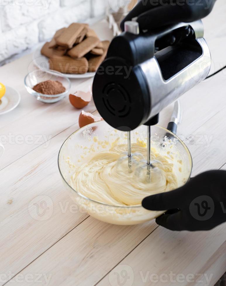 Manos masculinas mezclar masa bisquick con batidora eléctrica en una cocina foto