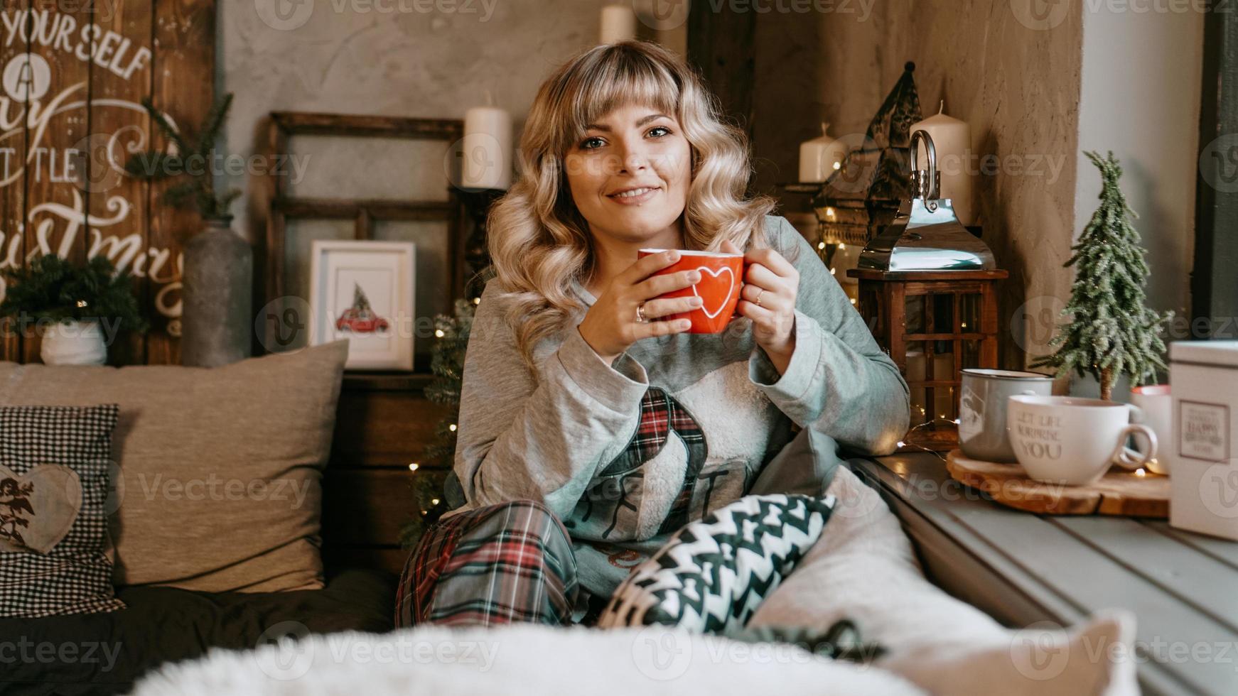 mujer joven, con, taza de té, en, navidad, acogedor, interior foto