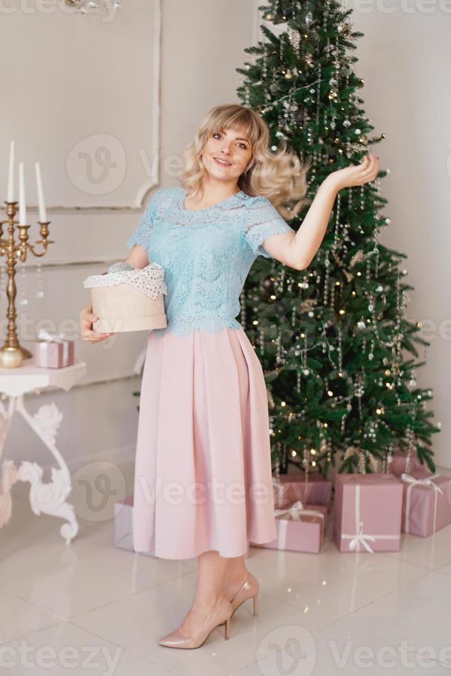 mujer joven decora el árbol de navidad con juguetes de navidad foto