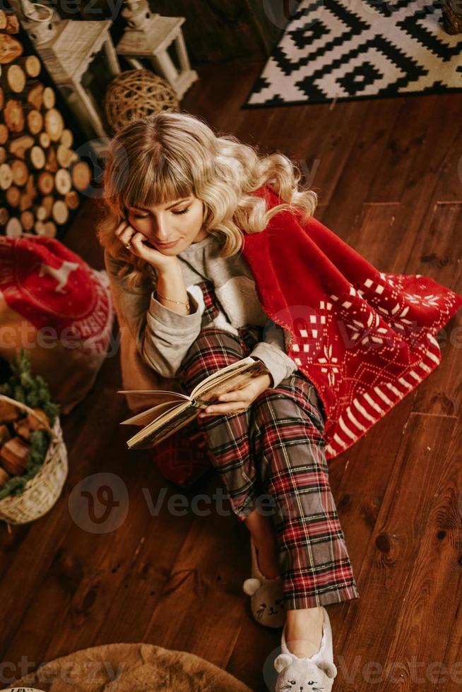 feliz, mujer joven, libro de lectura, delante de, navidad, interior foto