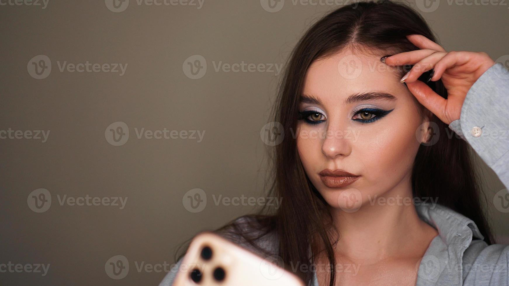 Young attractive model make a selfie after makeup in beauty studio photo