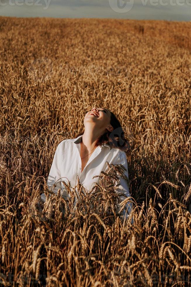naturaleza de verano, mujer joven feliz en los oídos de un campo de centeno foto