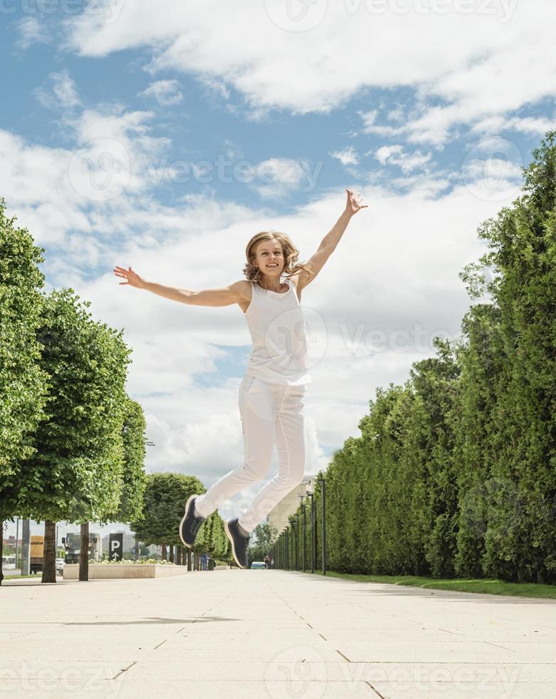 Pretty young woman jumping in the park photo