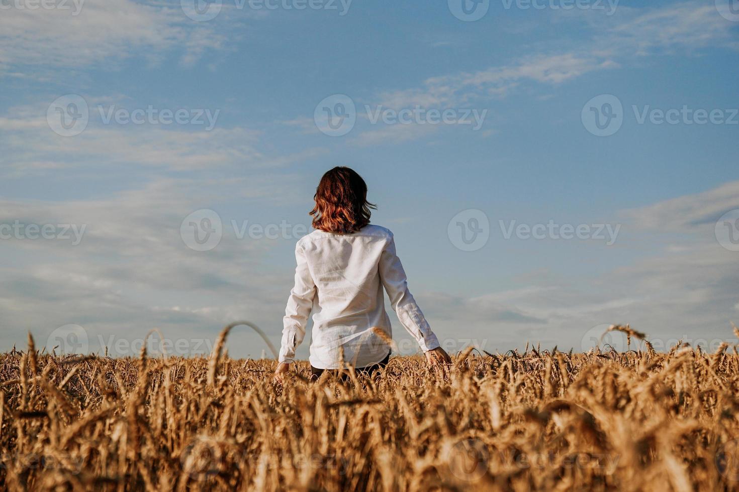 A woman in rye field. View from the back. The concept of harmony photo