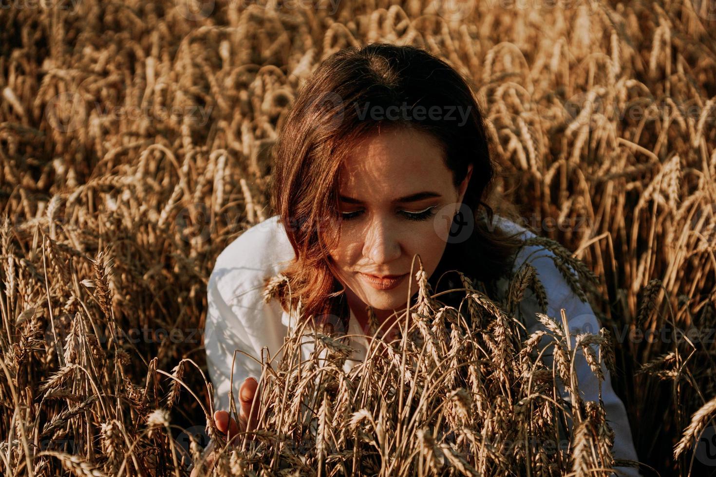 Woman in a rye field. She breathes in the scent of fresh ears photo