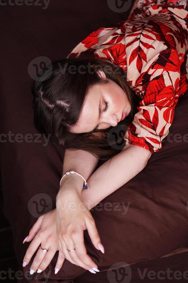 Relaxed woman lying on a brown bed photo