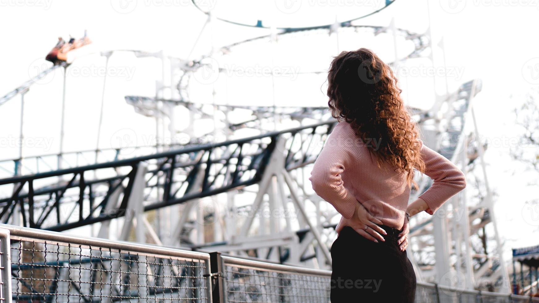 Beautiful smiling girl on a background of a roller coaster photo