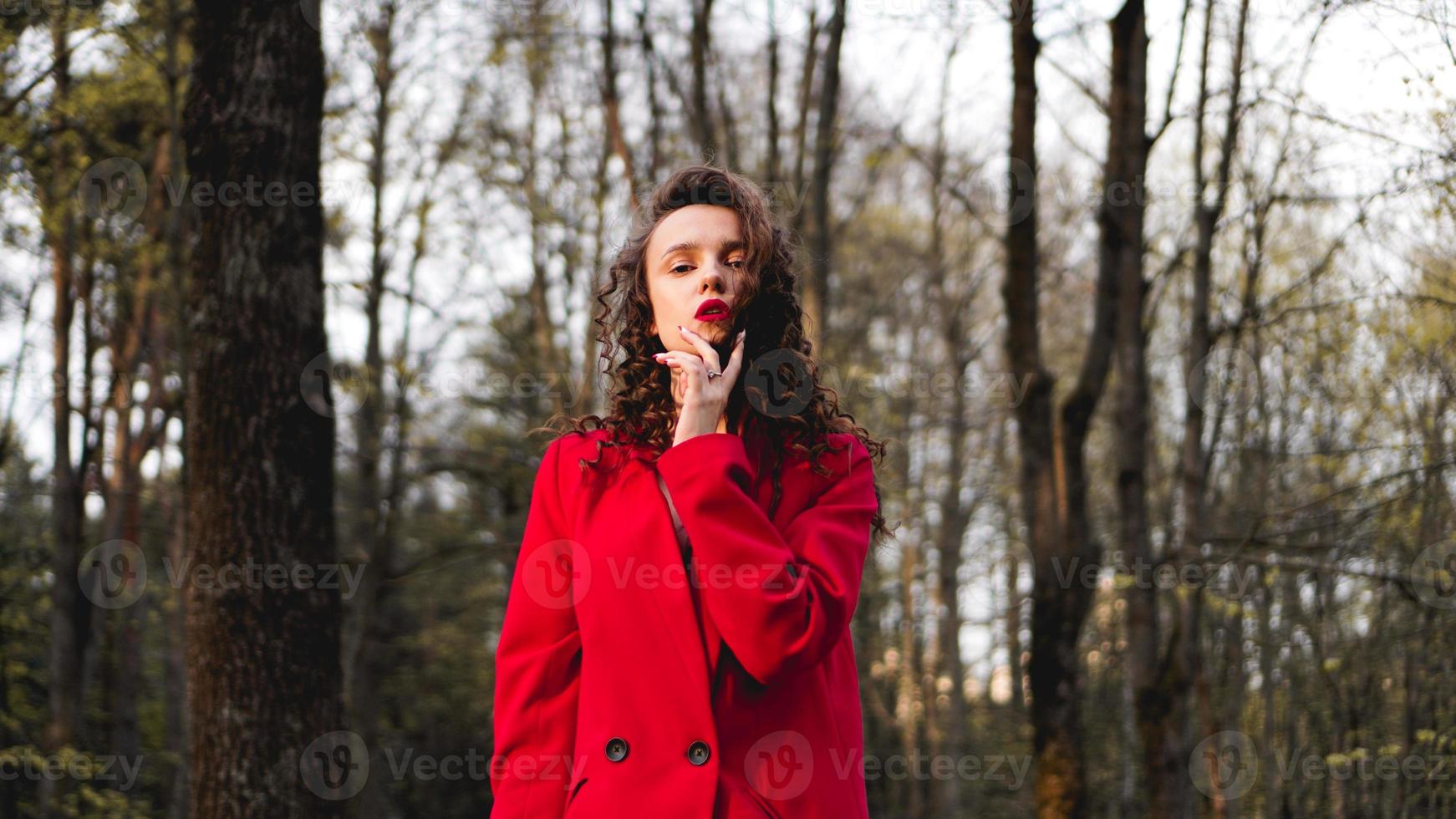 mujer glamorosa con traje rojo y brillo de labios rojo a juego. foto