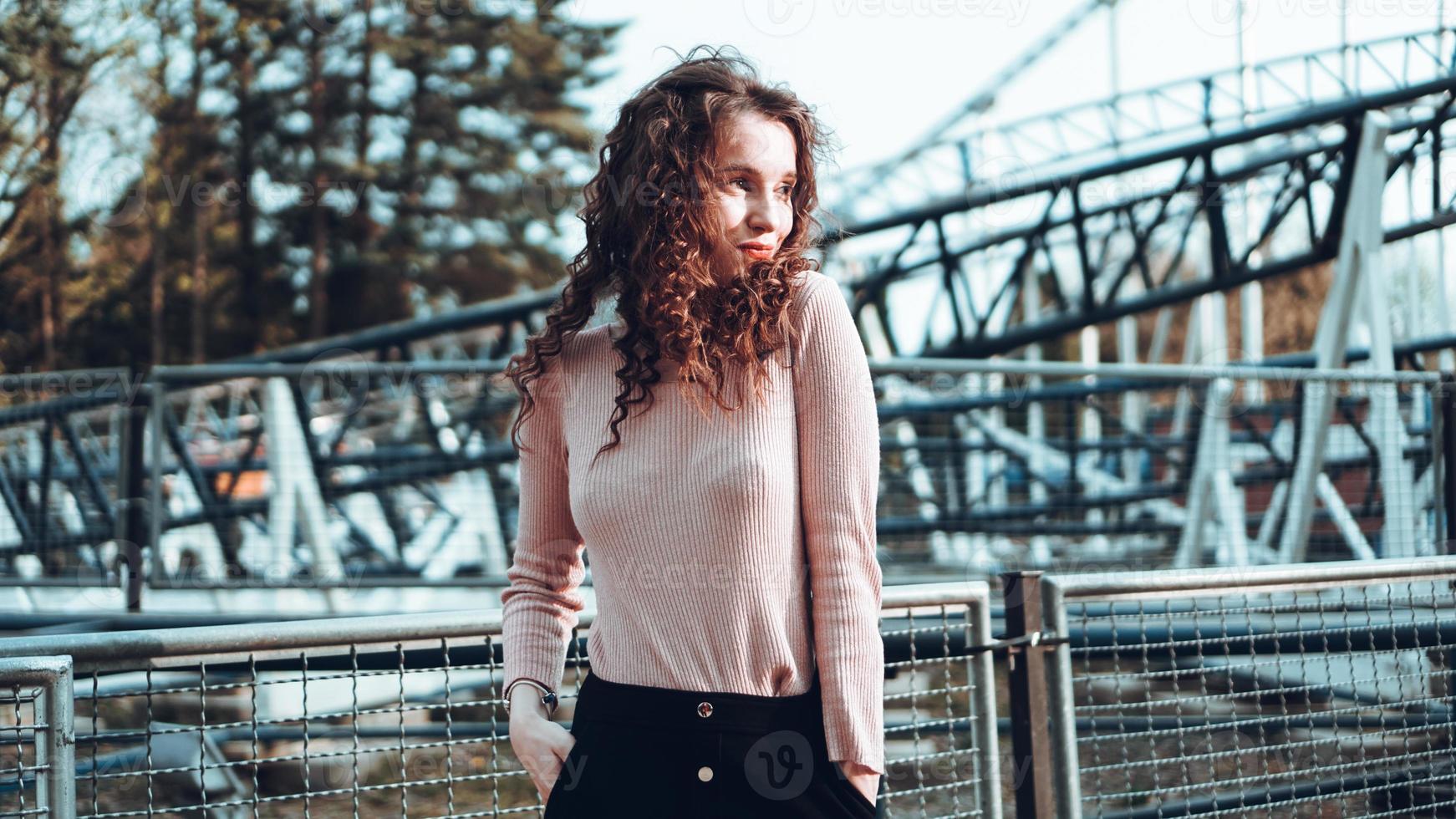 Beautiful smiling girl on a background of a roller coaster photo