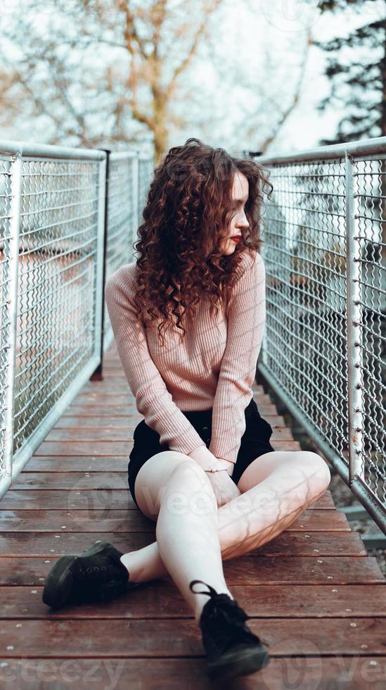 Fashion portrait of trendy young woman sitting near the netting rabitz photo