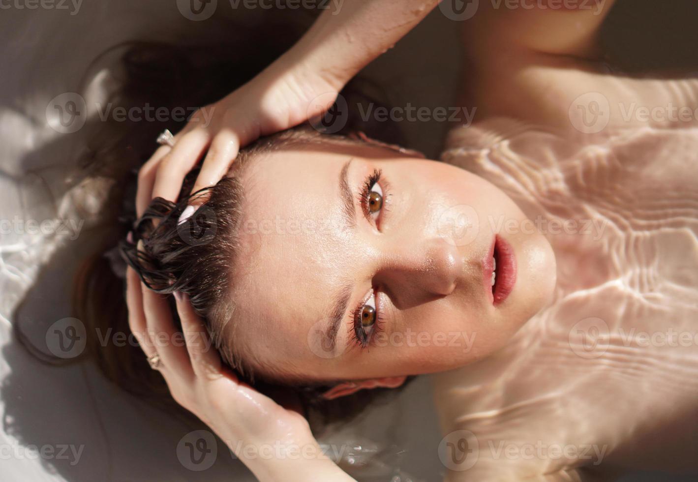 Vista superior de la hermosa joven tomando un baño foto