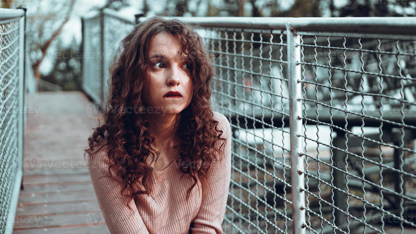 Retrato de moda de moda joven sentado cerca de la red rabitz foto