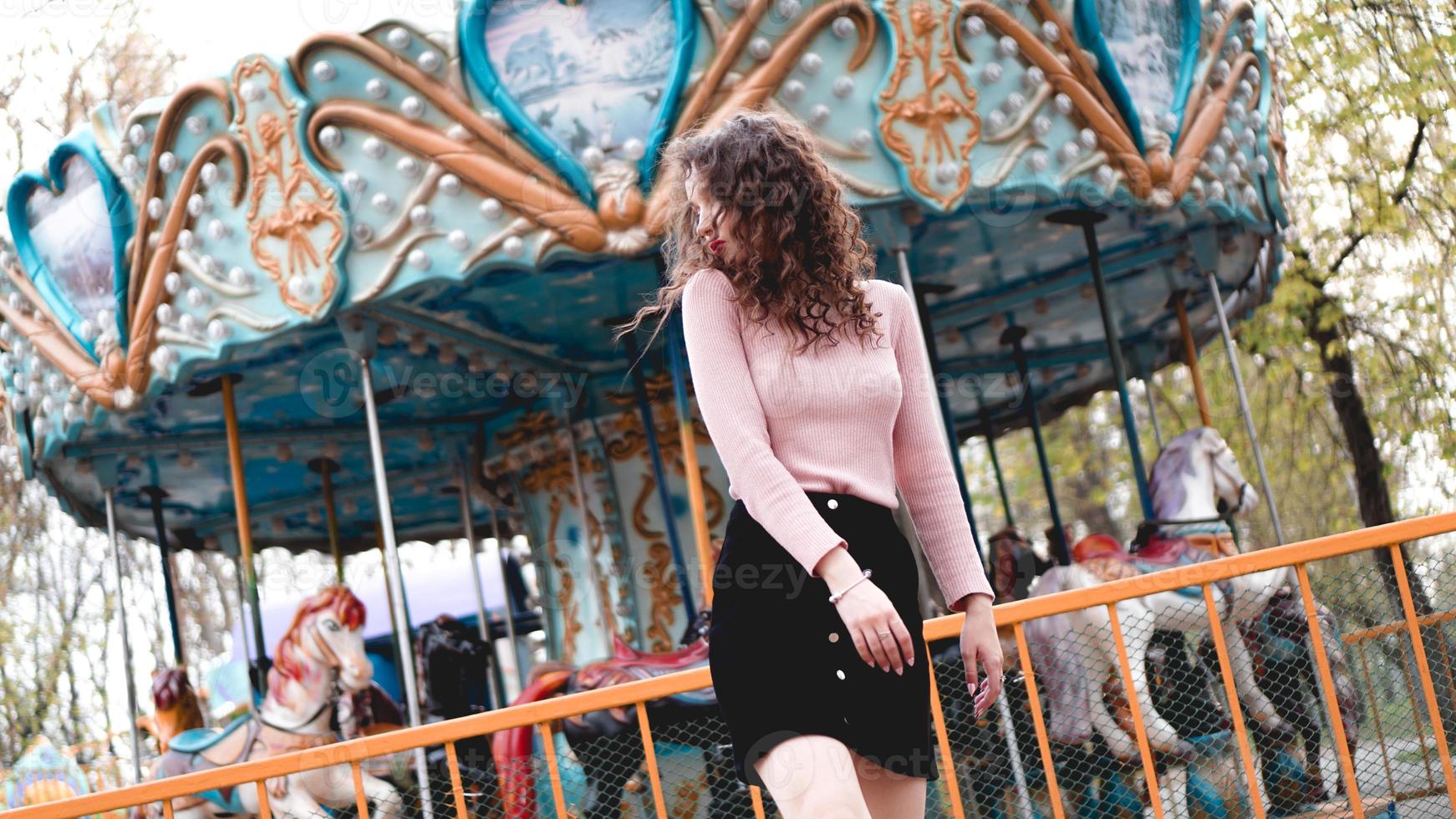 Girl chilling in amusement park in weekend morning. Laughing model photo