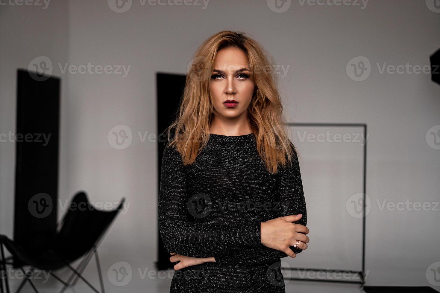 Bella mujer en pose de vestido clásico negro en estudio foto