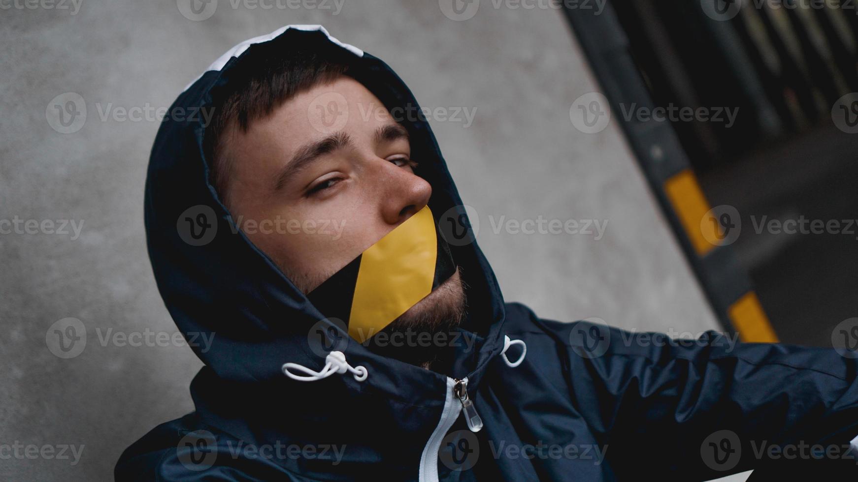hombre con cinta adhesiva en la boca foto