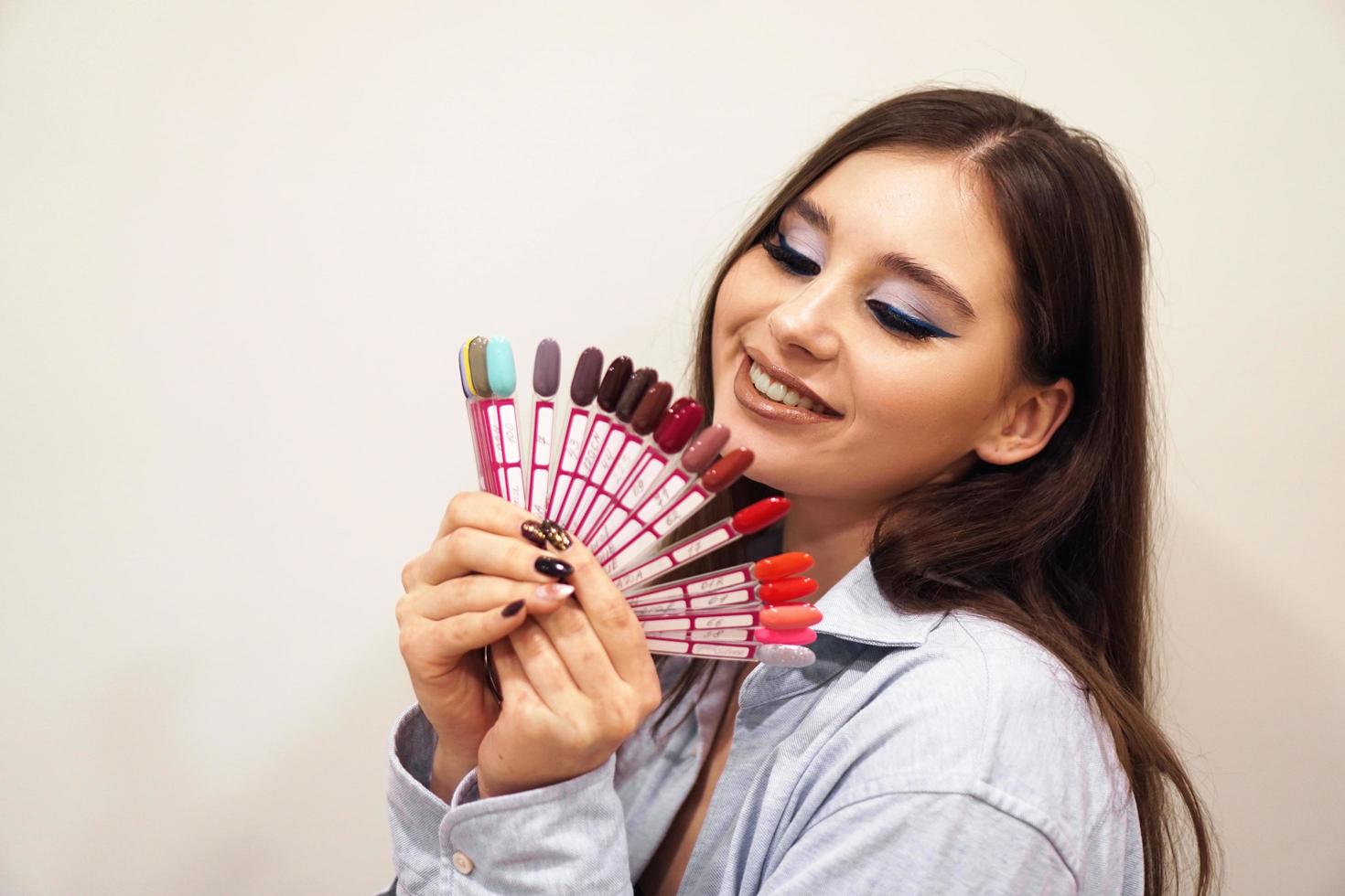 Woman smiling, holding a manicure and pedicure nail polish palette photo