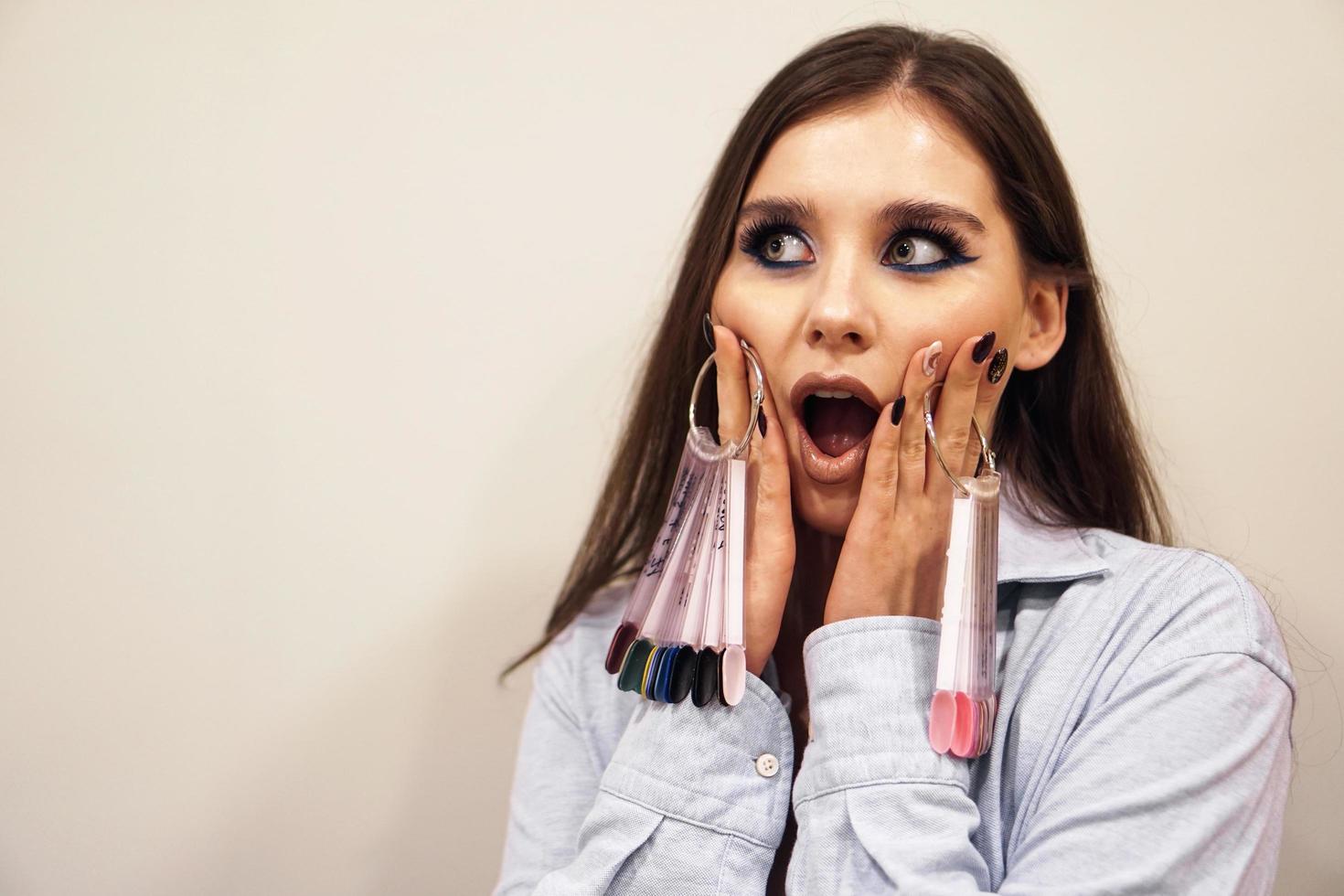 mujer sosteniendo una paleta de uñas. ella esta impresionada foto