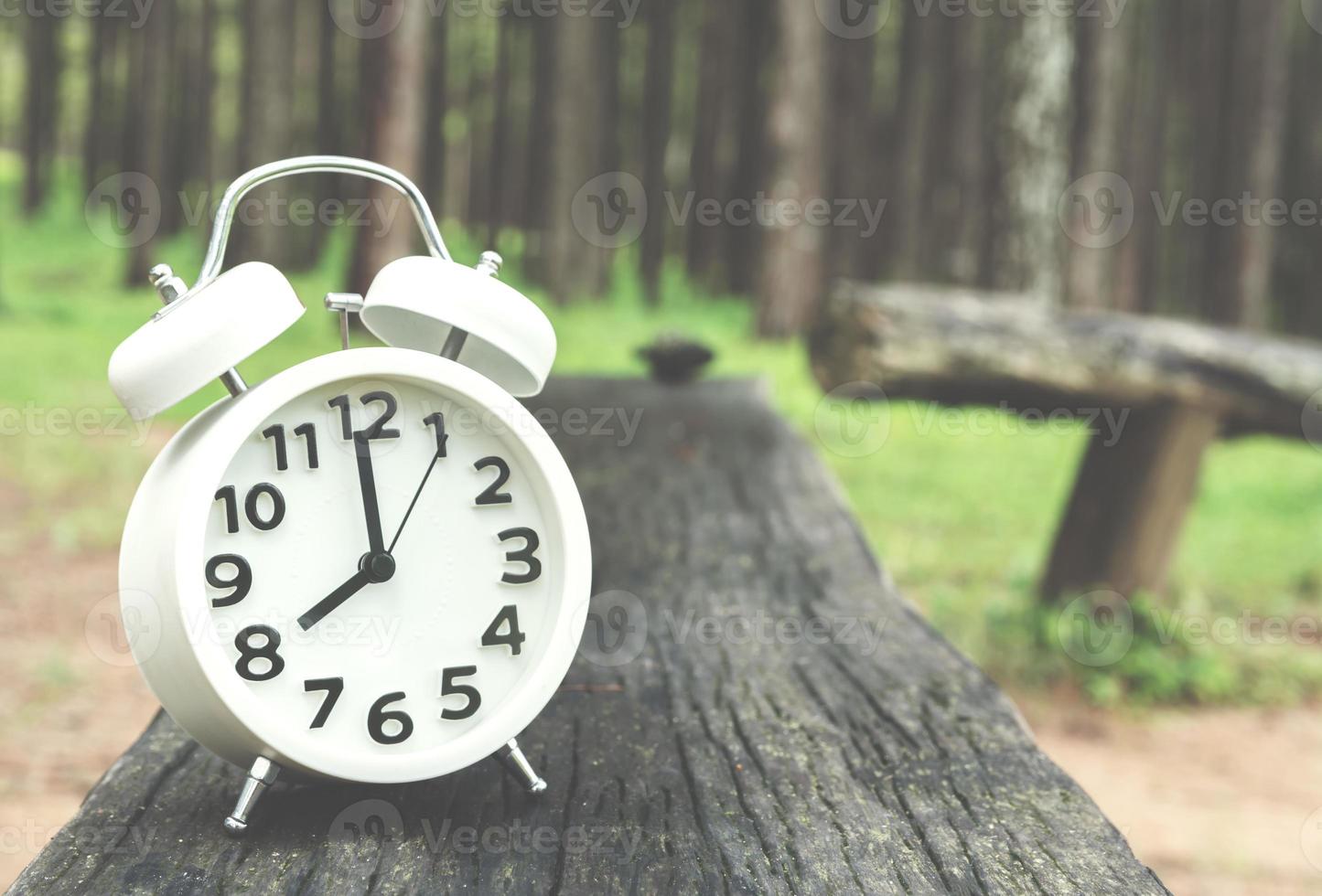 white alarm clock on wooden table photo