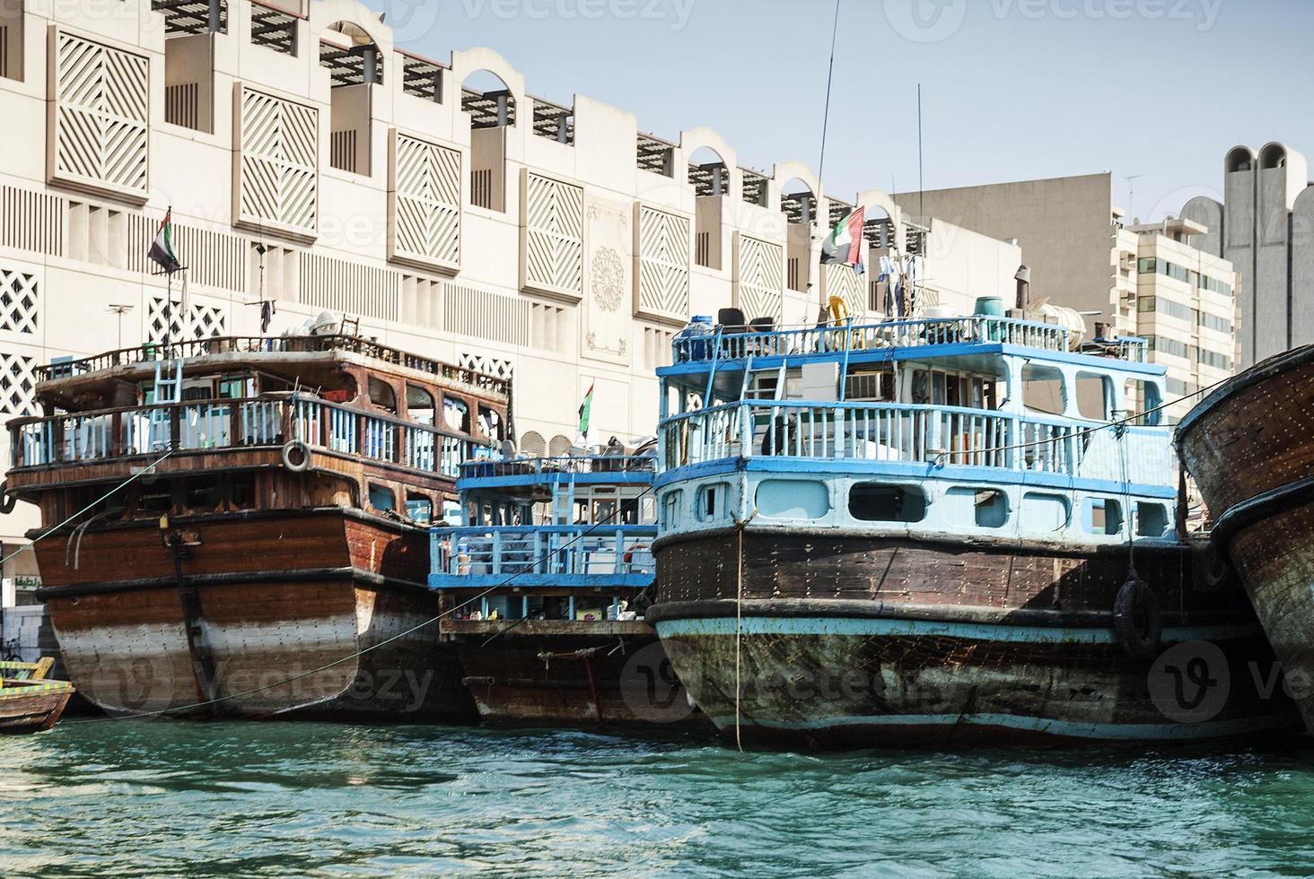 Antiguos barcos de dhow de madera árabe tradicional en el puerto de Deira del puerto de Dubai, Emiratos Árabes Unidos foto