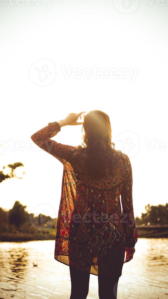 espalda de mujer descansando sobre la naturaleza cerca del río foto